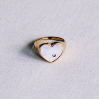 Mother-of-pearl heart ring worn on hand